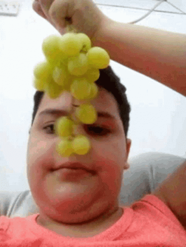 Menino segurando uva